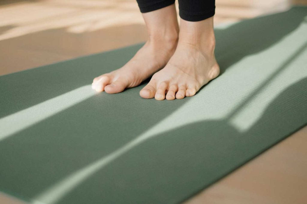 Pair of feet on green yoga mat